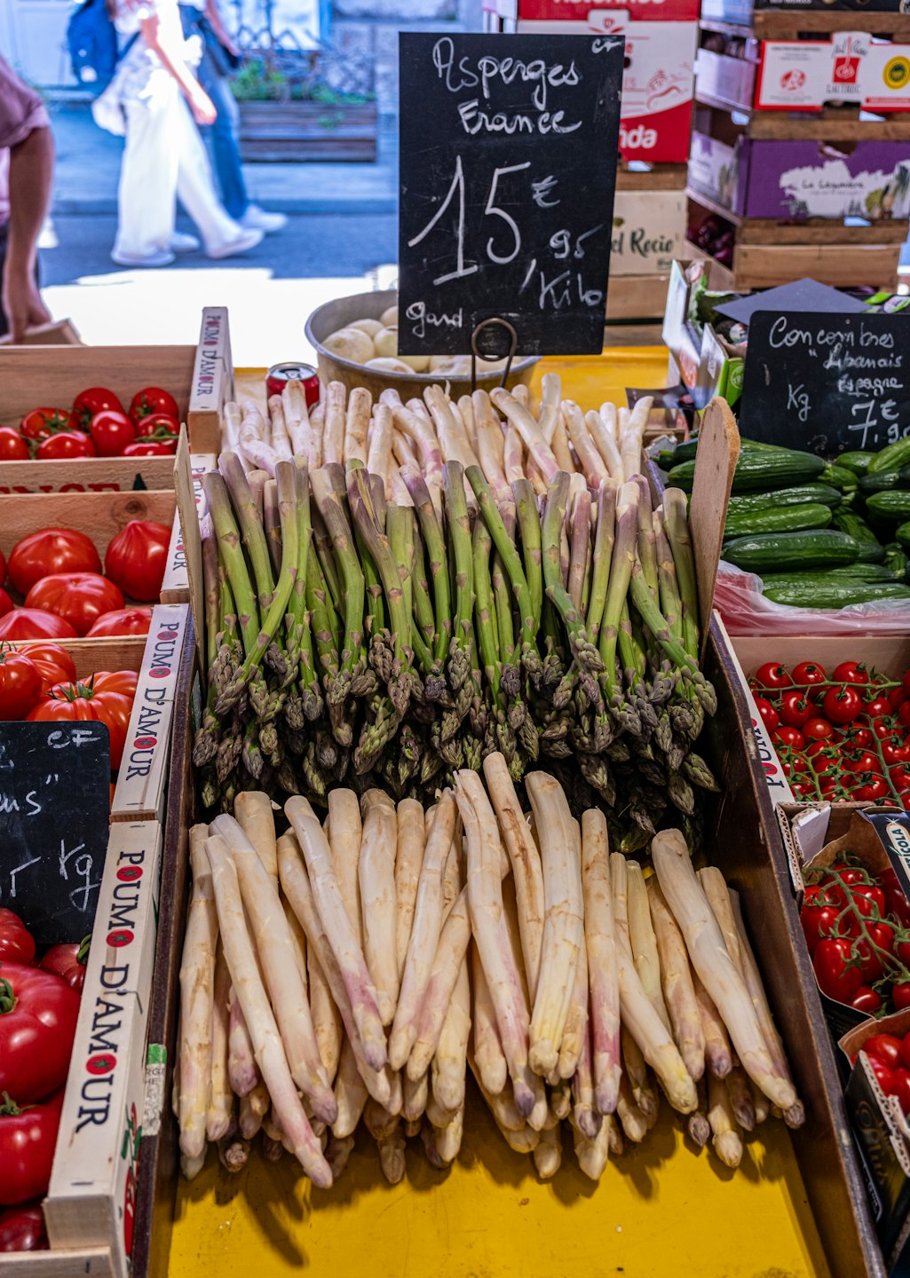 Asparagi freschi e verdure esposte su un banco del mercato.